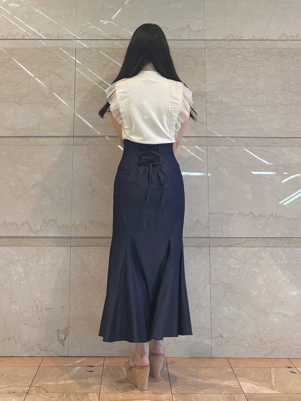 ブルー系のスカート、ホワイト系のニット/セーター、その他のサンダルを着用したレディースの春コーディネートの3枚目の写真