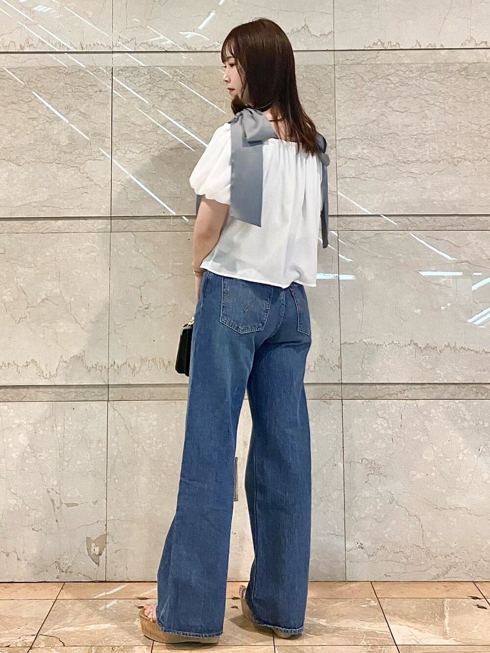 ホワイト系のシャツ/ブラウス、ブルー系のデニムパンツ、その他のサンダルを着用したレディースの春コーディネートの3枚目の写真