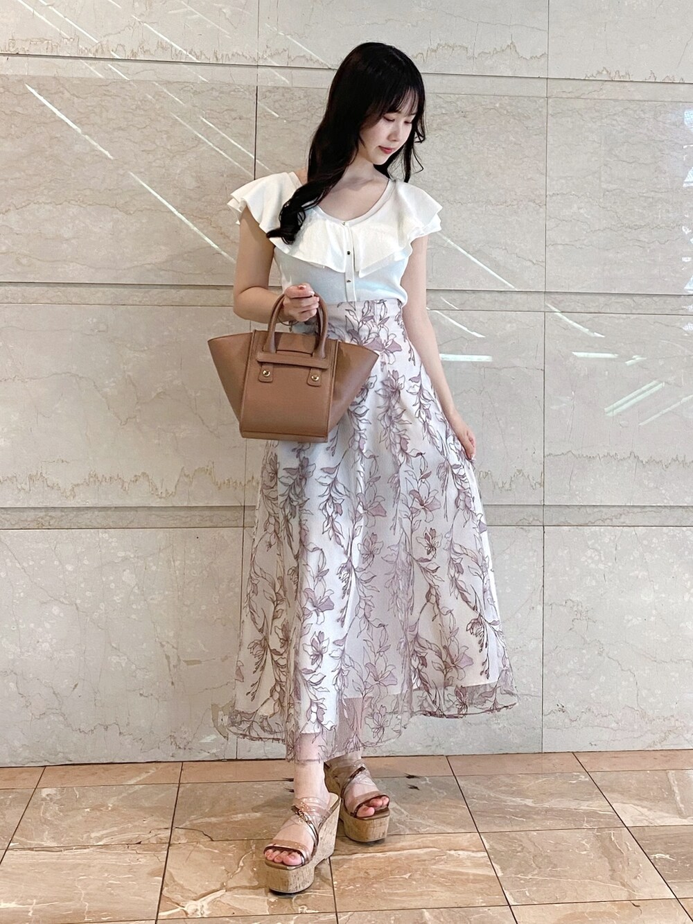 ピンク系のスカート、ホワイト系のニット/セーター、ブラウン系のトートバッグを着用したレディースの夏コーディネートの3枚目の写真