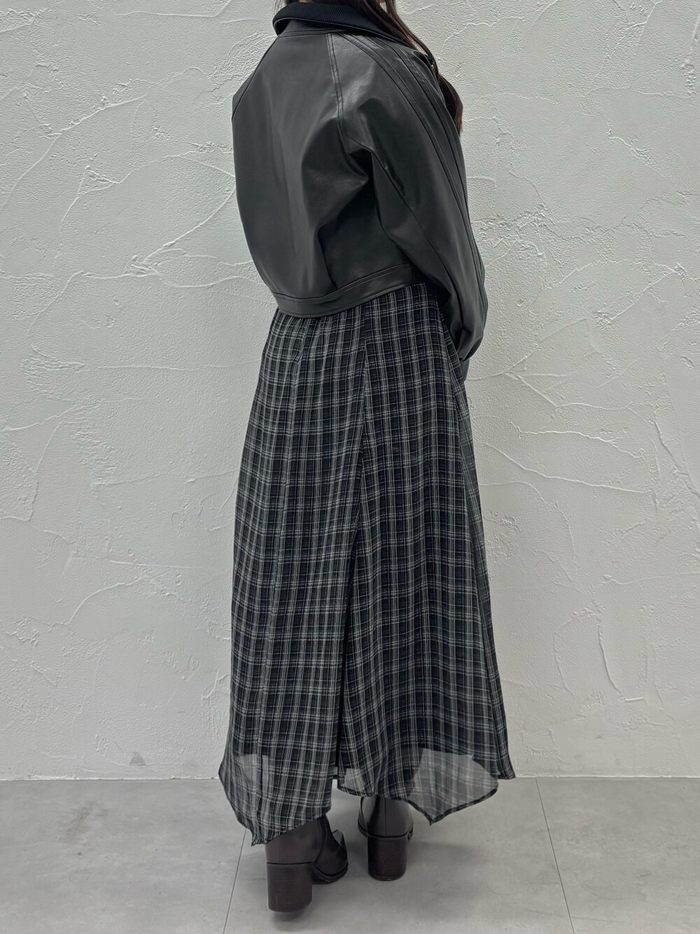 ブラック系のワンピース、ブラウン系のブーツ、ブラック系のブルゾンを着用したレディースの秋コーディネートの3枚目の写真