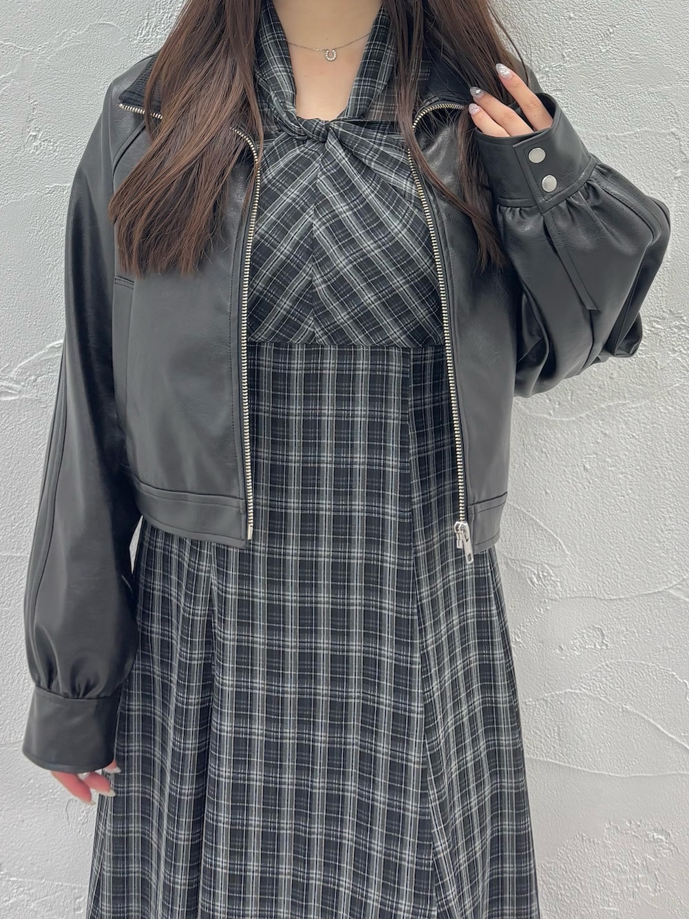 ブラック系のワンピース、ブラウン系のブーツ、ブラック系のブルゾンを着用したレディースの秋コーディネートの4枚目の写真