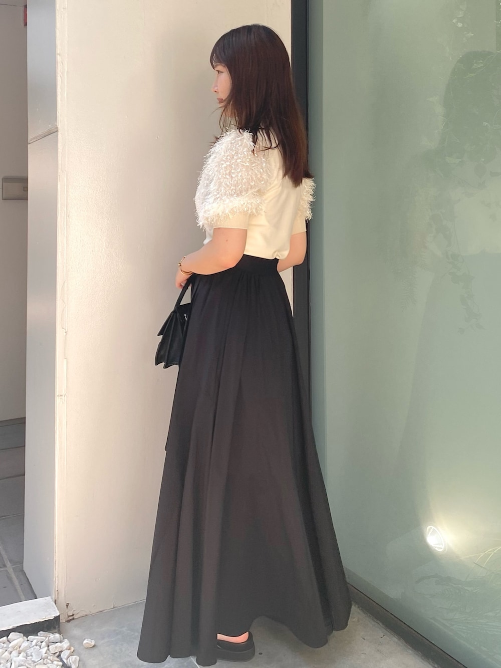 ブラック系のショルダーバッグ、ブラック系のサンダル、ブラック系のスカートを着用したレディースの夏コーディネートの4枚目の写真