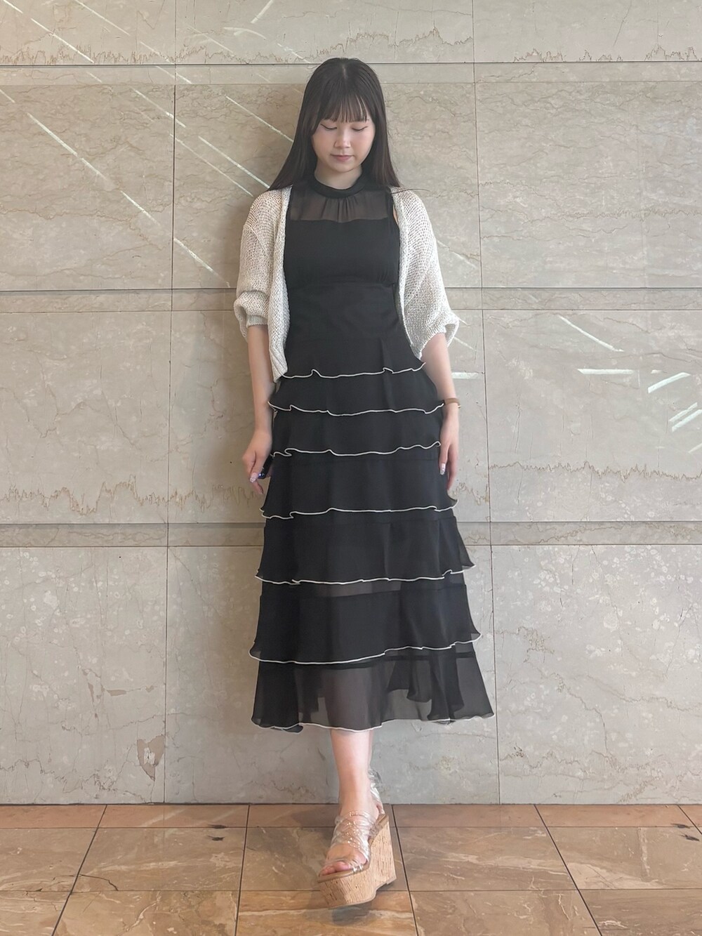 ブラック系のワンピース、その他のサンダル、ホワイト系のカーディガン/ボレロを着用したレディースの夏コーディネートの2枚目の写真