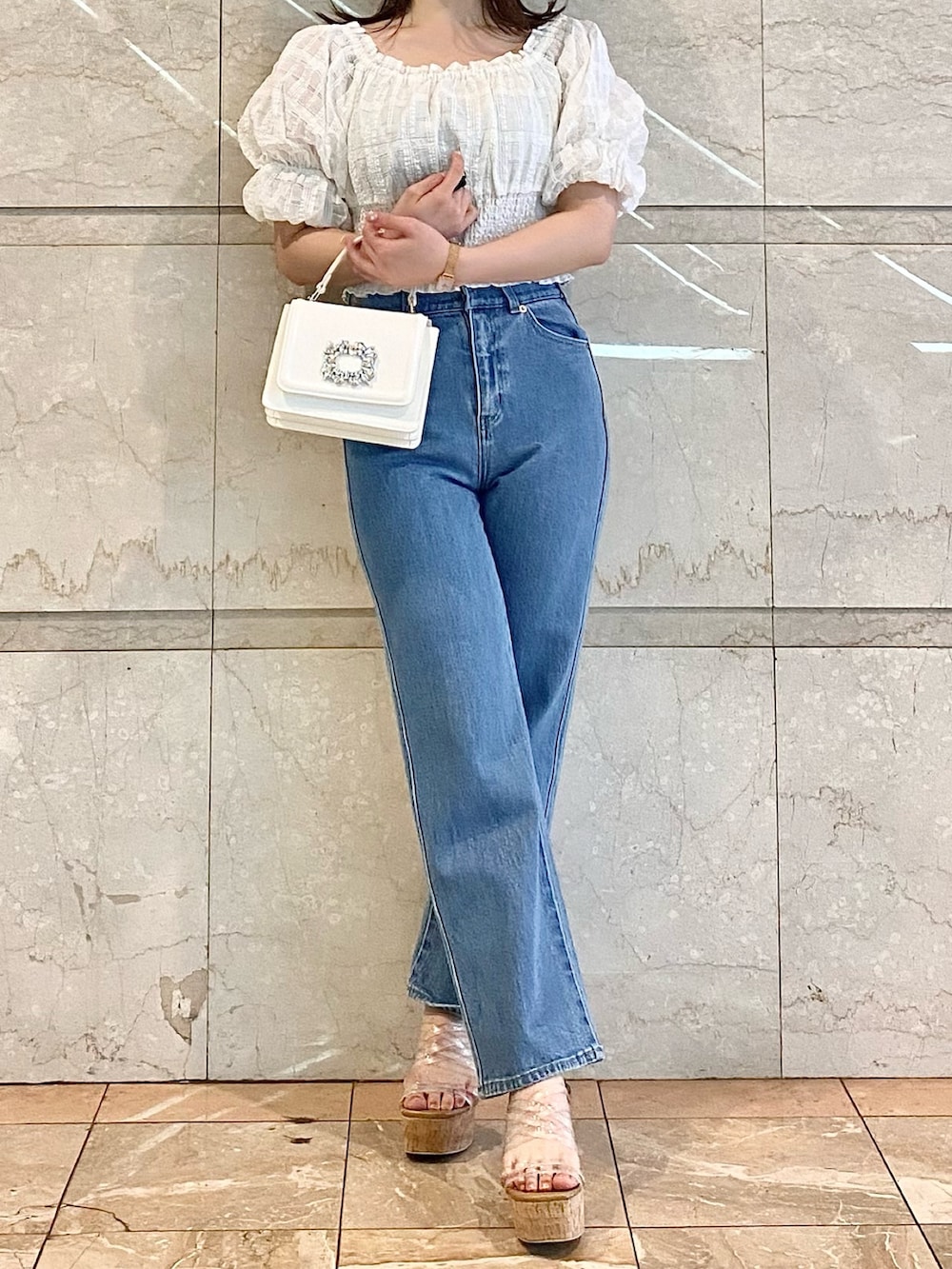 ホワイト系のショルダーバッグ、ホワイト系のシャツ/ブラウス、ブルー系のデニムパンツを着用したレディースの春コーディネートの2枚目の写真
