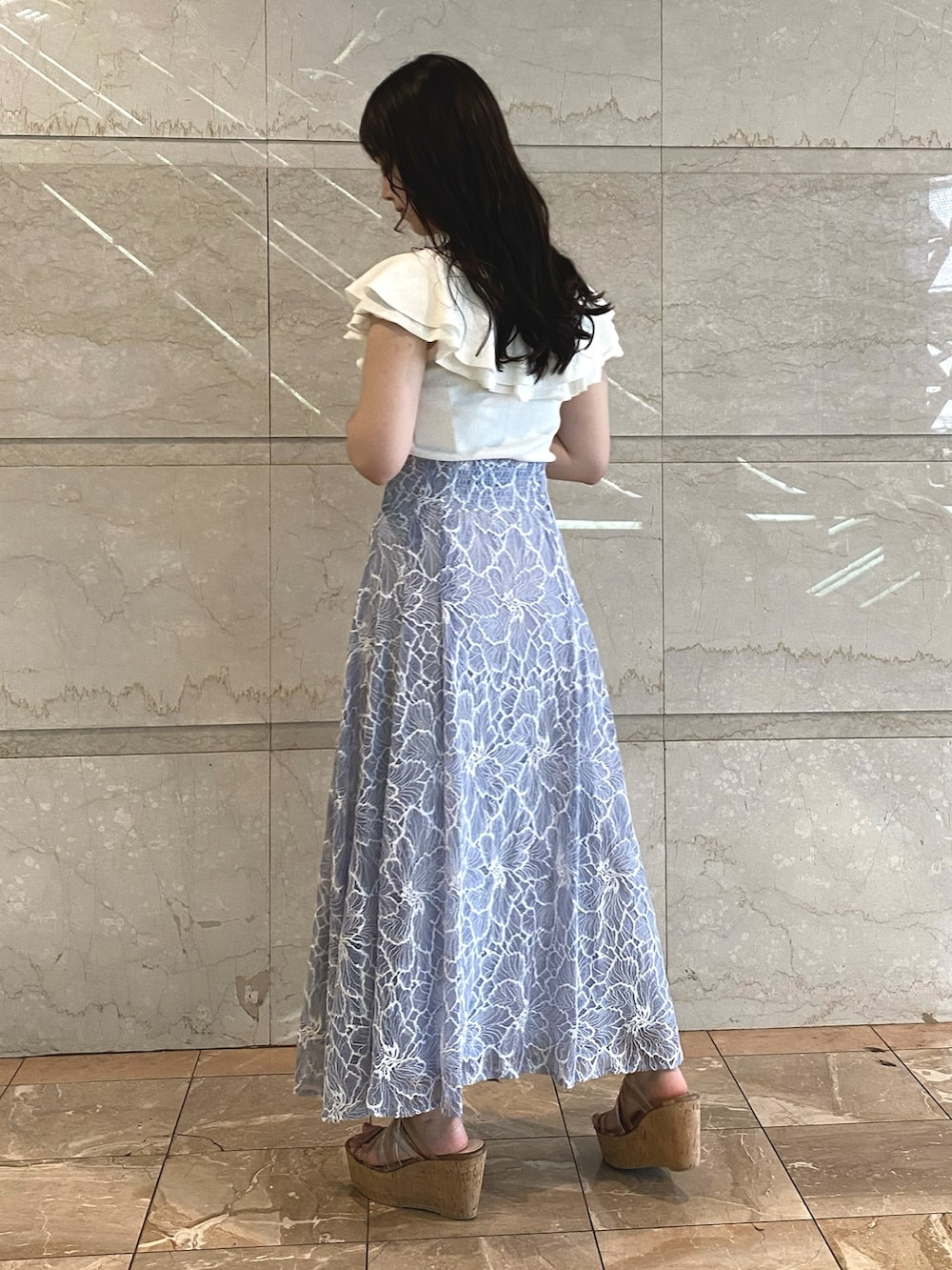 ブルー系のスカート、ホワイト系のニット/セーターを着用したレディースの夏コーディネートの5枚目の写真