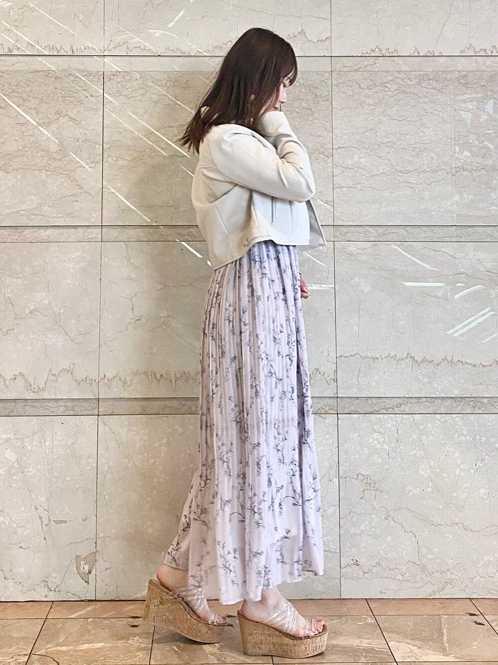 ピンク系のワンピース、その他のサンダル、グレー系のライダースジャケットを着用したレディースの春コーディネートの3枚目の写真