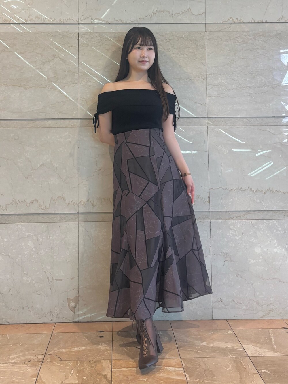 ブラウン系のブーツ、ブラウン系のスカート、ブラック系のニット/セーターを着用したレディースの夏コーディネートの2枚目の写真