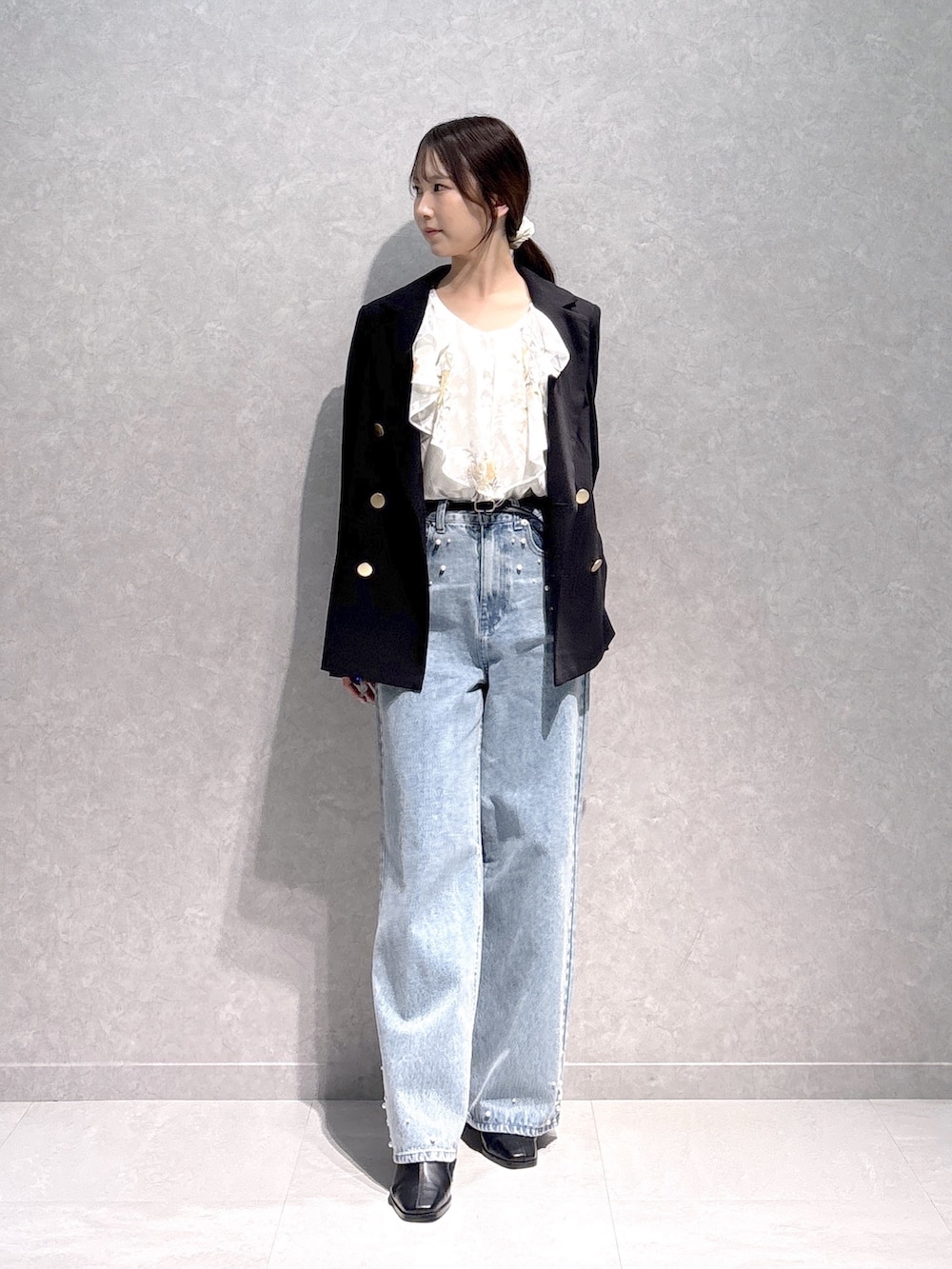 ブルー系のデニムパンツ、ホワイト系のシャツ/ブラウス、ブラック系のテーラードジャケットを着用したレディースの秋コーディネートの2枚目の写真