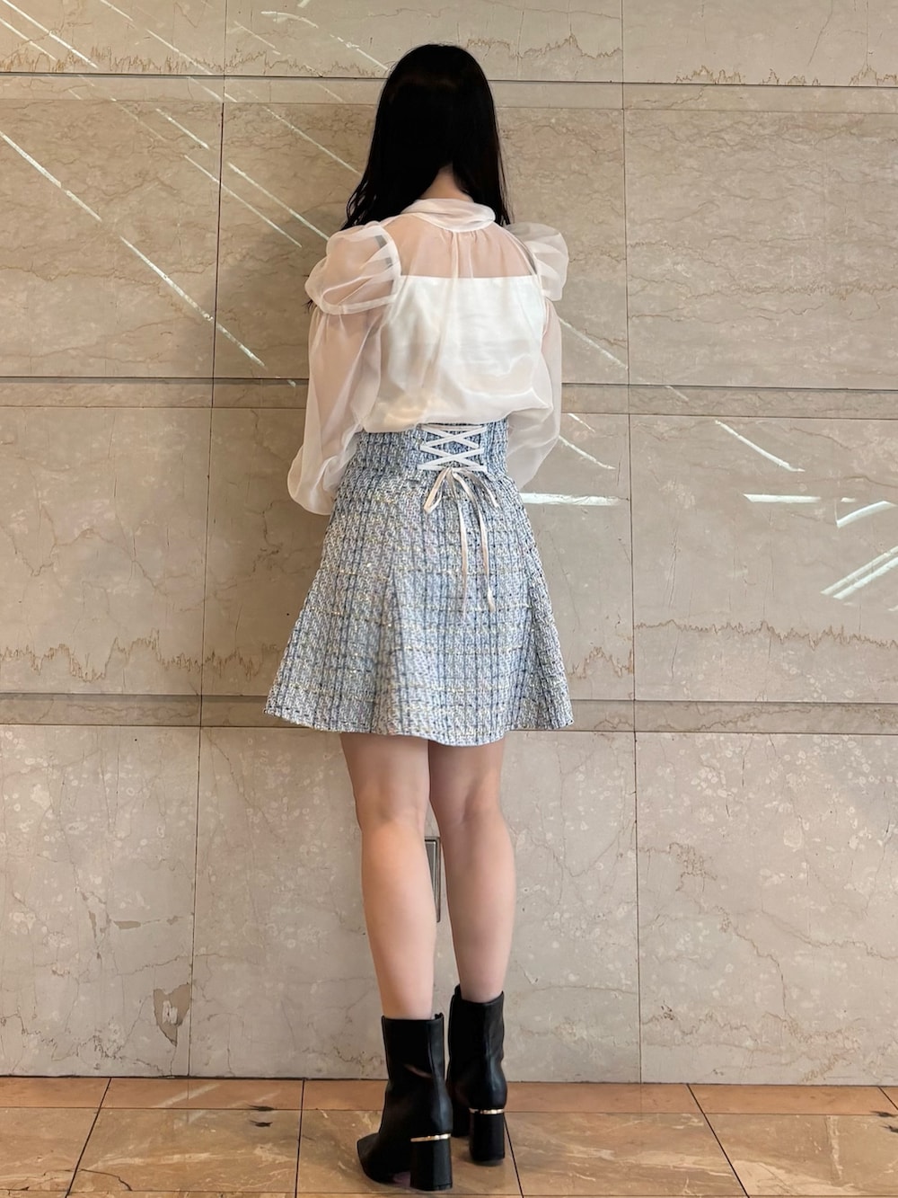 ブルー系のスカート、ホワイト系のシャツ/ブラウス、ブラック系のブーツを着用したレディースの冬コーディネートの3枚目の写真