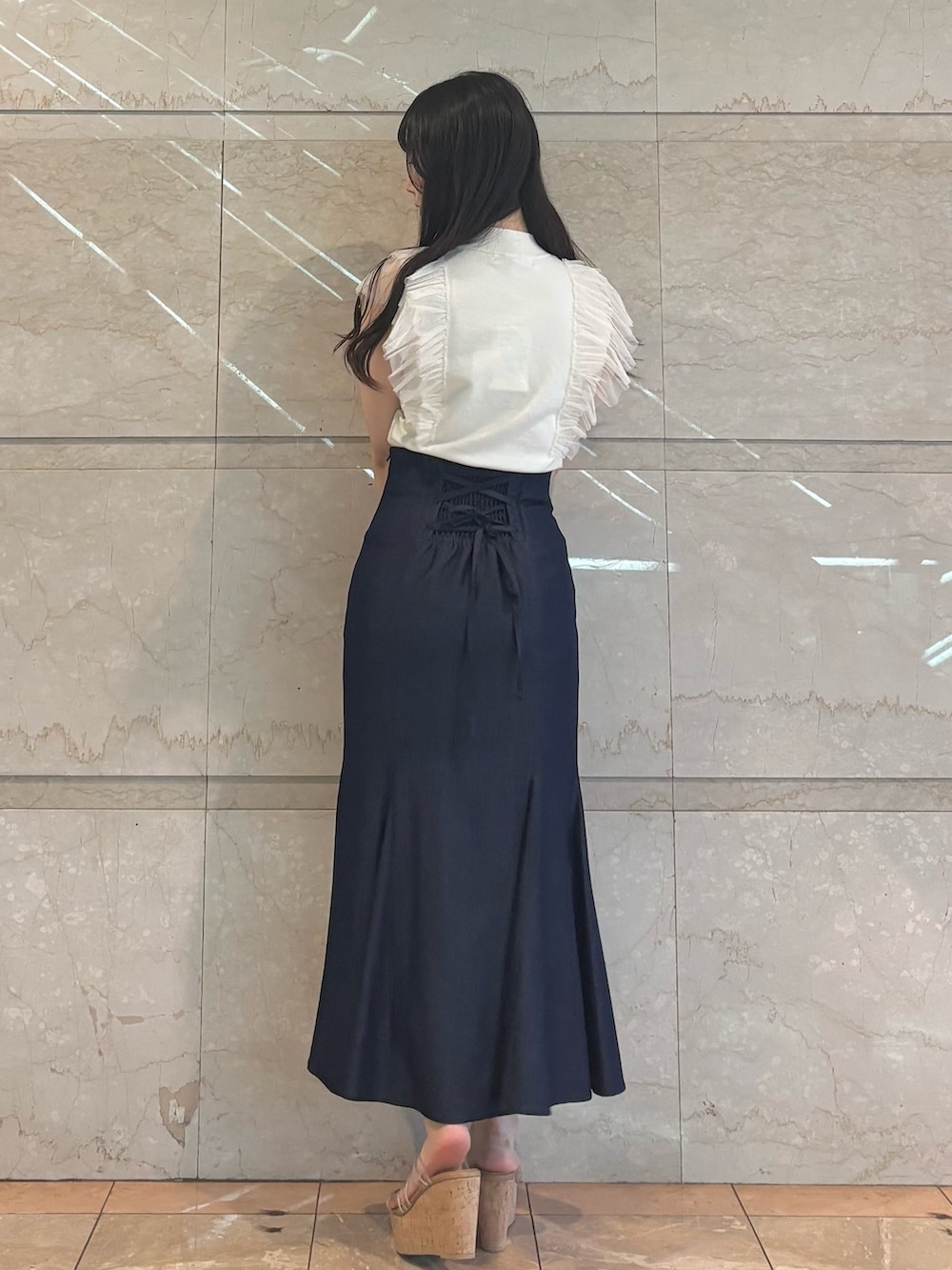 ブルー系のスカート、ホワイト系のニット/セーター、その他のサンダルを着用したレディースの春コーディネートの4枚目の写真