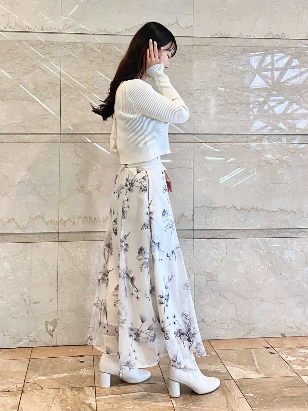 ホワイト系のスカート、ホワイト系のカーディガン/ボレロ、ホワイト系のブーツを着用したレディースの冬コーディネートの4枚目の写真