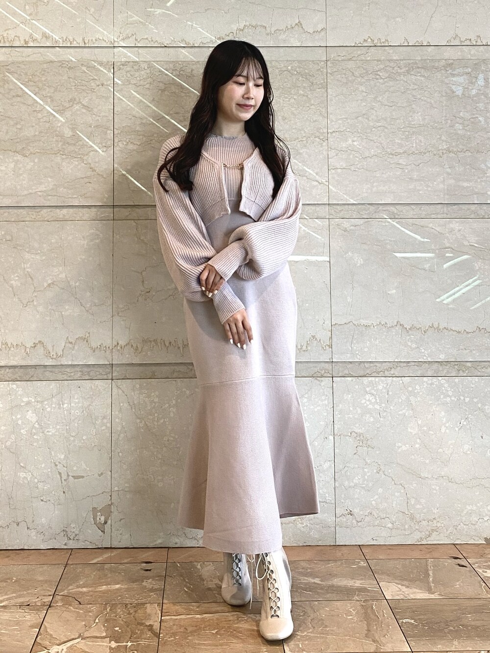ピンク系のワンピース、ホワイト系のブーツを着用したレディースの秋コーディネートの2枚目の写真