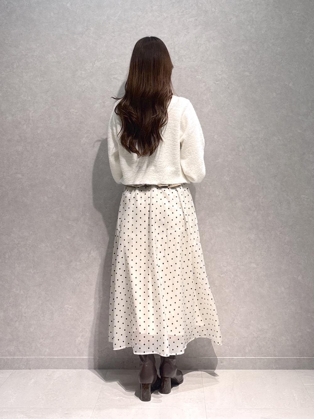 ベージュ系のワンピース、ホワイト系のカーディガン/ボレロ、ブラウン系のブーツを着用したレディースの秋コーディネートの5枚目の写真