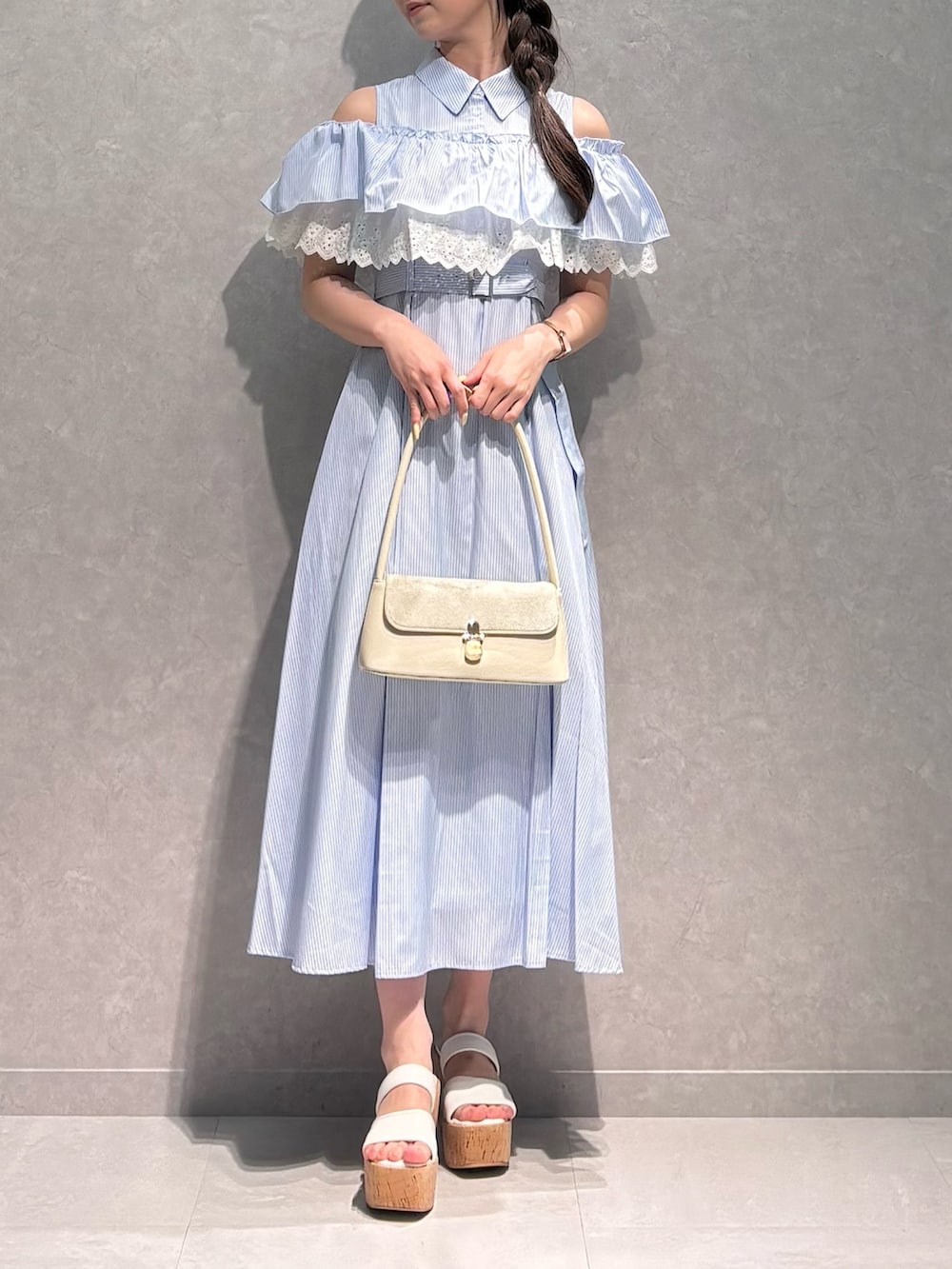 ブルー系のワンピース、ホワイト系のサンダル、ホワイト系のハンドバッグを着用したレディースの夏コーディネートの2枚目の写真