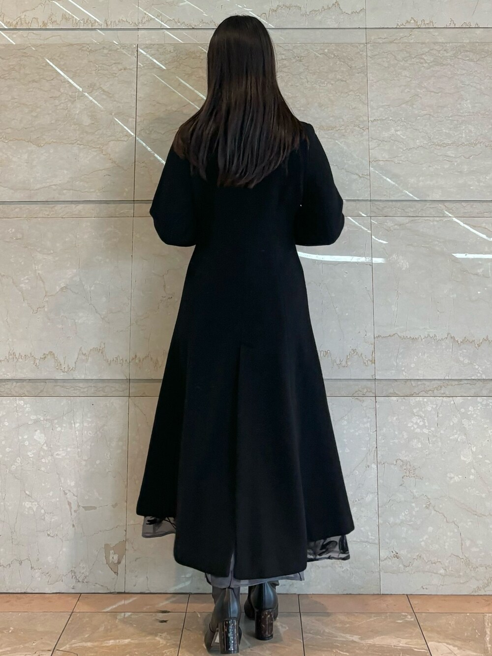 グレー系のスカート、ブラック系のその他アウター、ブラック系のニット/セーターを着用したレディースの冬コーディネートの4枚目の写真