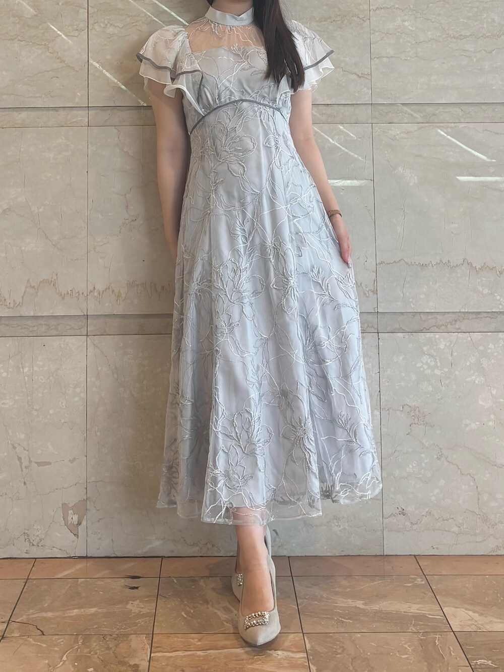 グレー系のドレス、ベージュ系のパンプスを着用したレディースの秋コーディネートの2枚目の写真