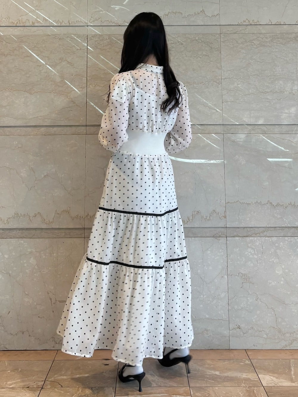 ホワイト系のワンピース、ブラック系のパンプスを着用したレディースの冬コーディネートの2枚目の写真