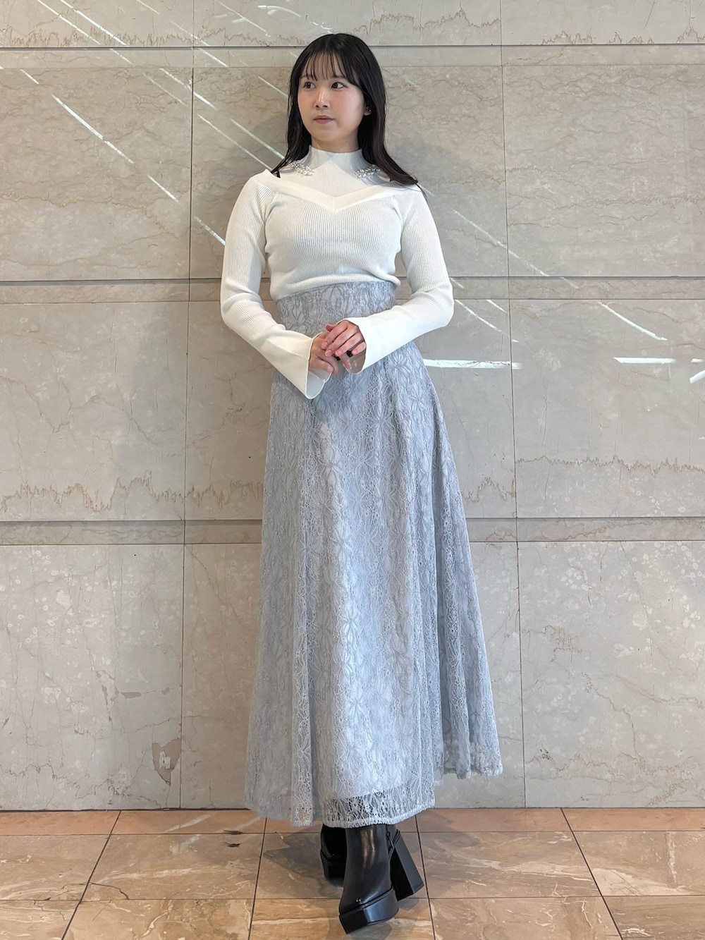 ブルー系のショルダーバッグ、ブラック系のブーツ、ブルー系のスカートを着用したレディースの冬コーディネートの3枚目の写真