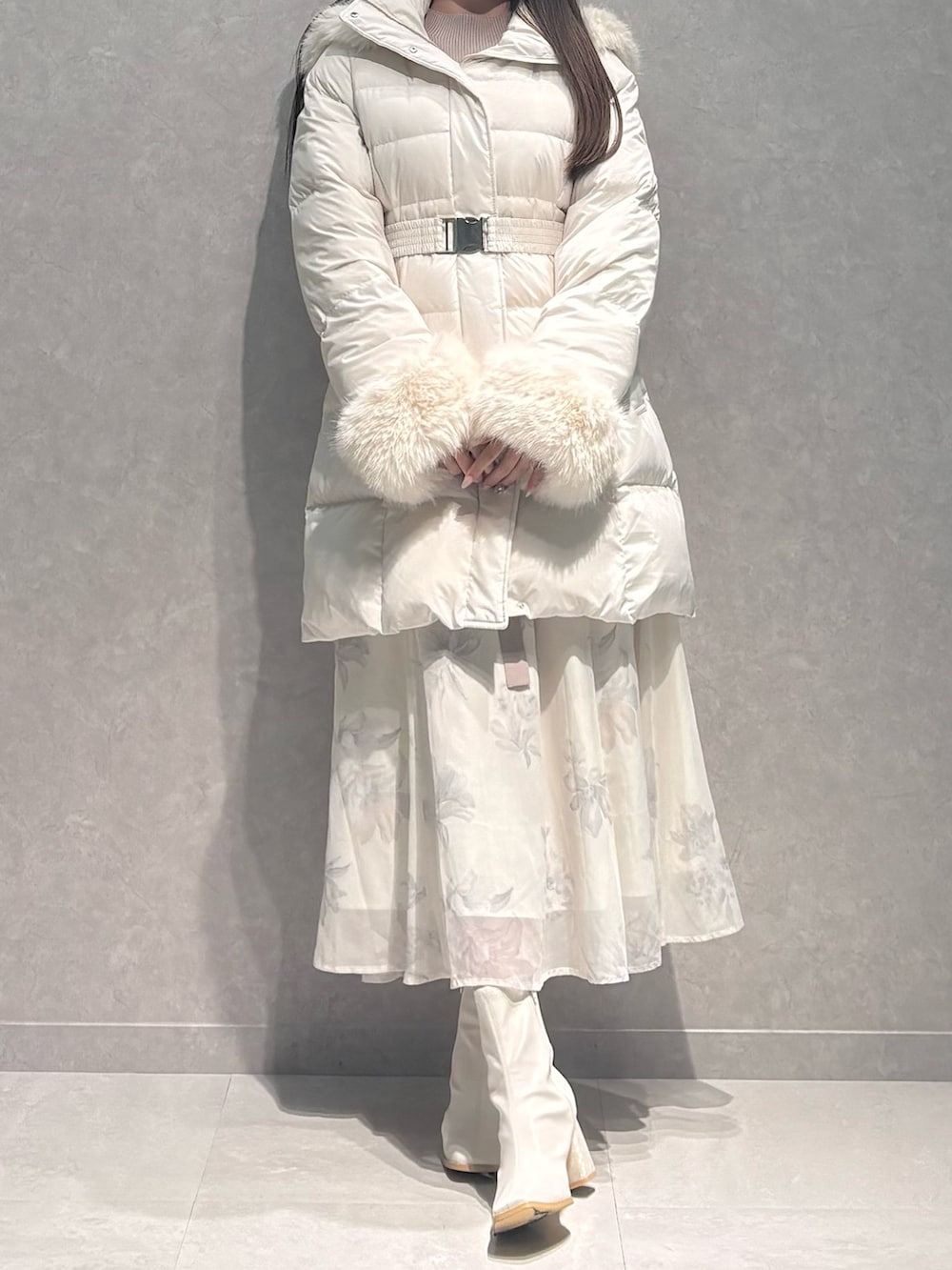 ベージュ系のワンピース、ホワイト系のダウンジャケット/コート、ホワイト系のブーツを着用したレディースの秋コーディネートの3枚目の写真