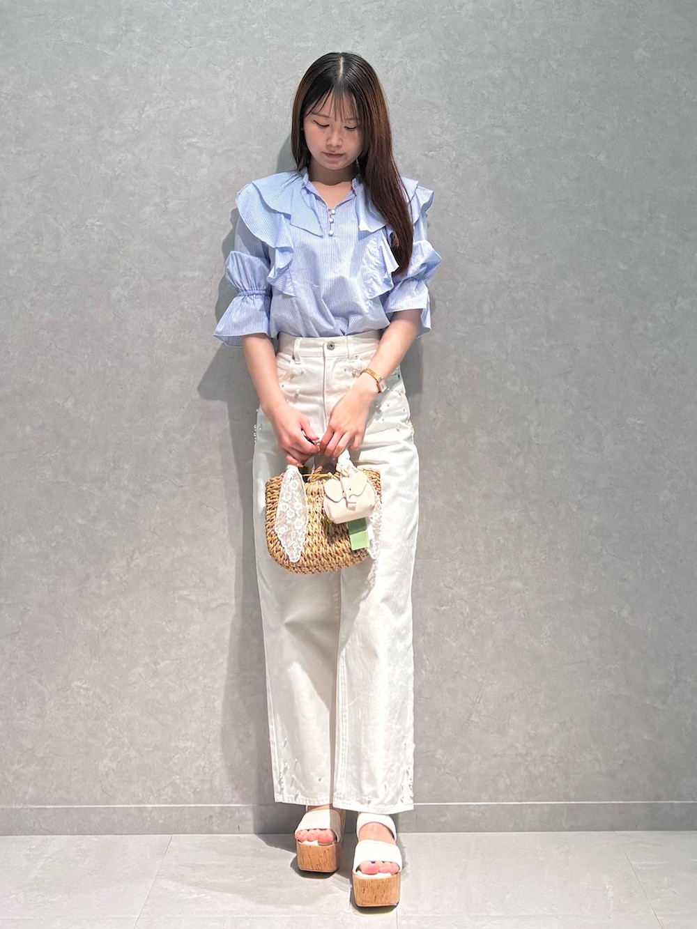 ホワイト系のデニムパンツ、ブルー系のシャツ/ブラウス、ベージュ系のハンドバッグを着用したレディースの春コーディネートの2枚目の写真