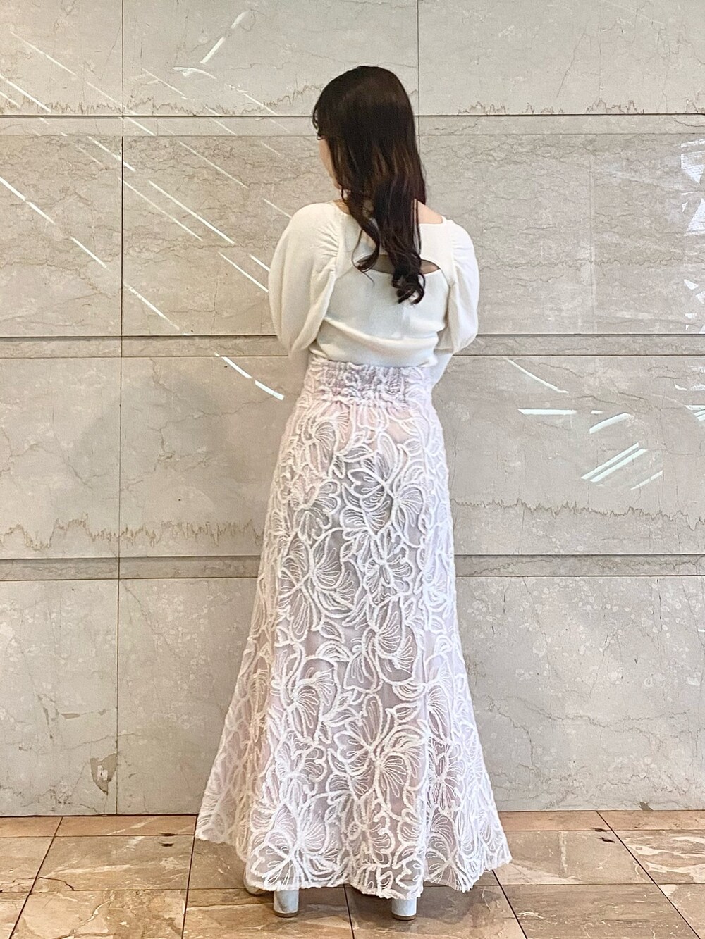 ピンク系のスカート、ホワイト系のブーツ、ホワイト系のニット/セーターを着用したレディースの冬コーディネートの5枚目の写真