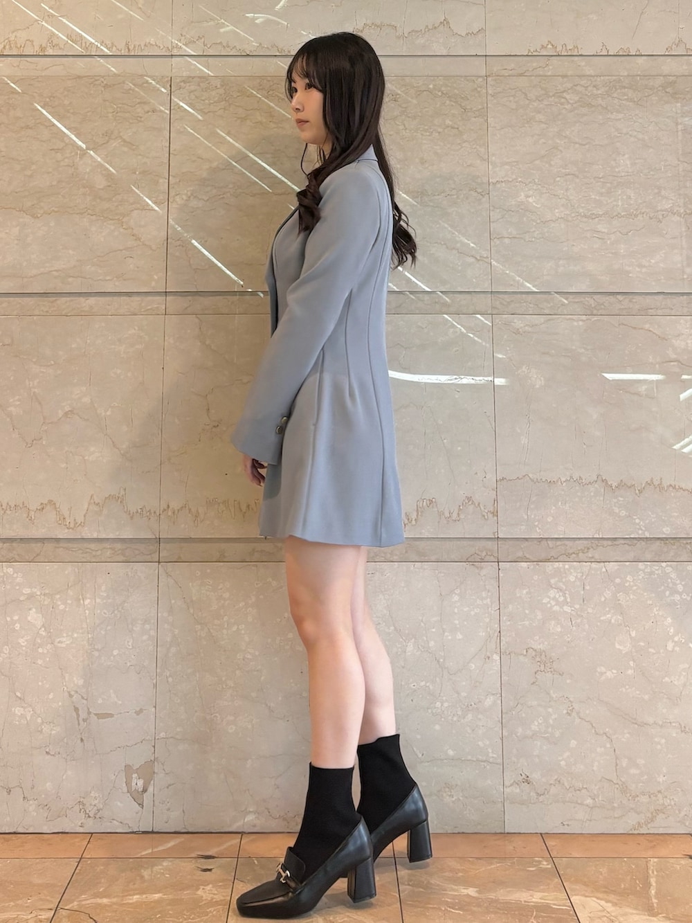 グレー系のワンピース、ブラック系のブーツを着用したレディースの冬コーディネートの2枚目の写真