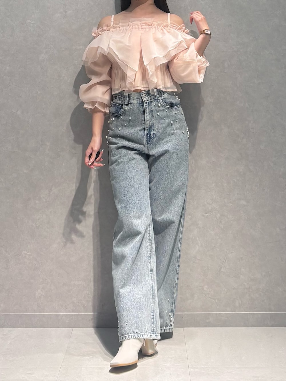 ブルー系のデニムパンツ、ピンク系のシャツ/ブラウス、ホワイト系のブーツを着用したレディースの春コーディネートの2枚目の写真