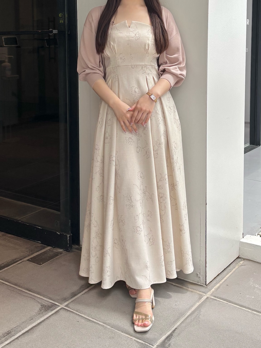 ホワイト系のワンピース、ホワイト系のサンダル、ベージュ系のカーディガン/ボレロを着用したレディースの夏コーディネートの2枚目の写真