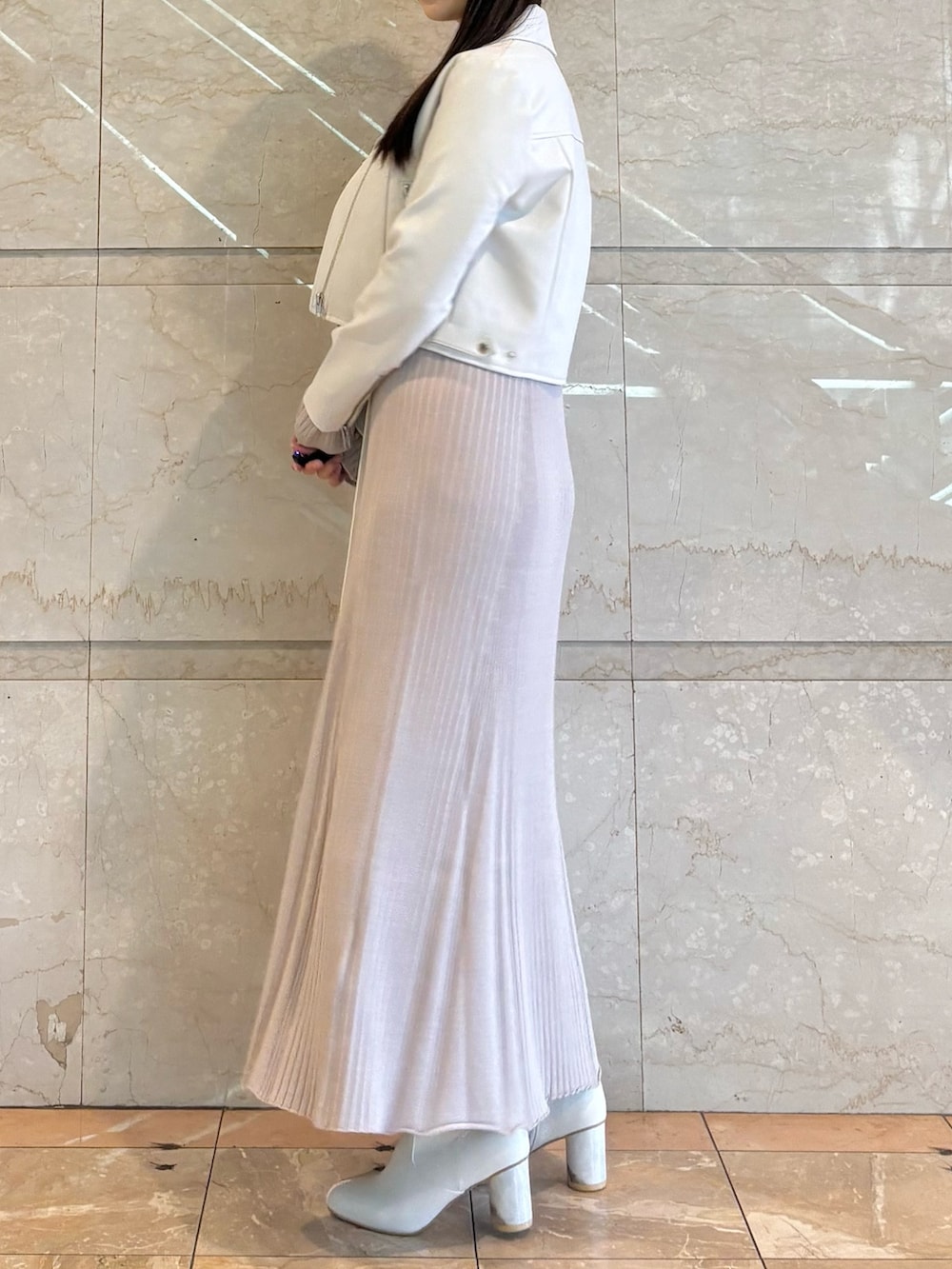 ピンク系のワンピース、ホワイト系のブーツ、ホワイト系のライダースジャケットを着用したレディースの冬コーディネートの2枚目の写真