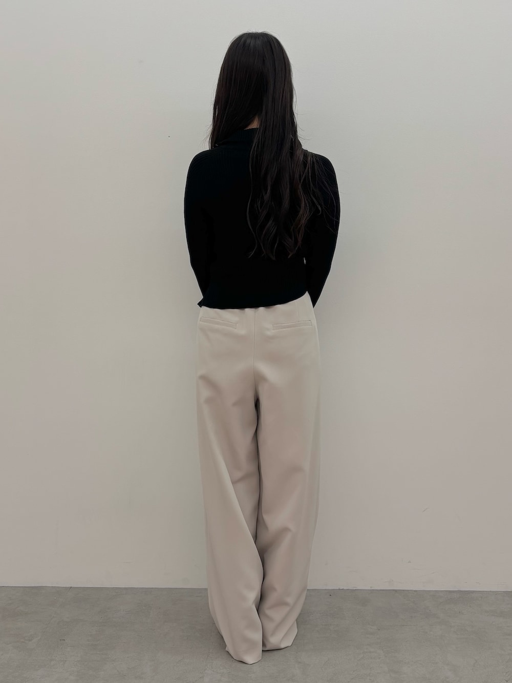 ブラック系のニット/セーター、ブラック系のハンドバッグ、ブラウン系のブーツを着用したレディースの秋コーディネートの4枚目の写真