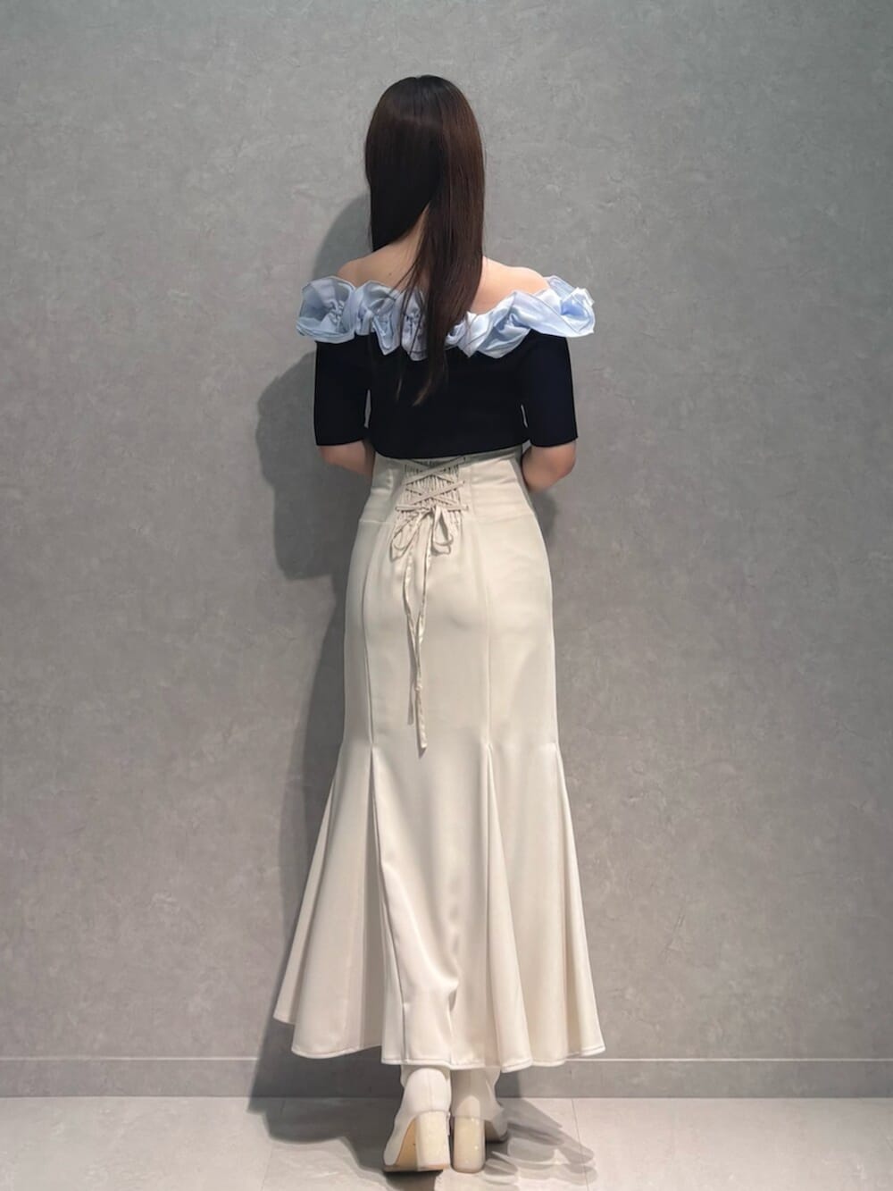 ホワイト系のブーツ、ホワイト系のスカート、ブルー系のニット/セーターを着用したレディースの春コーディネートの3枚目の写真