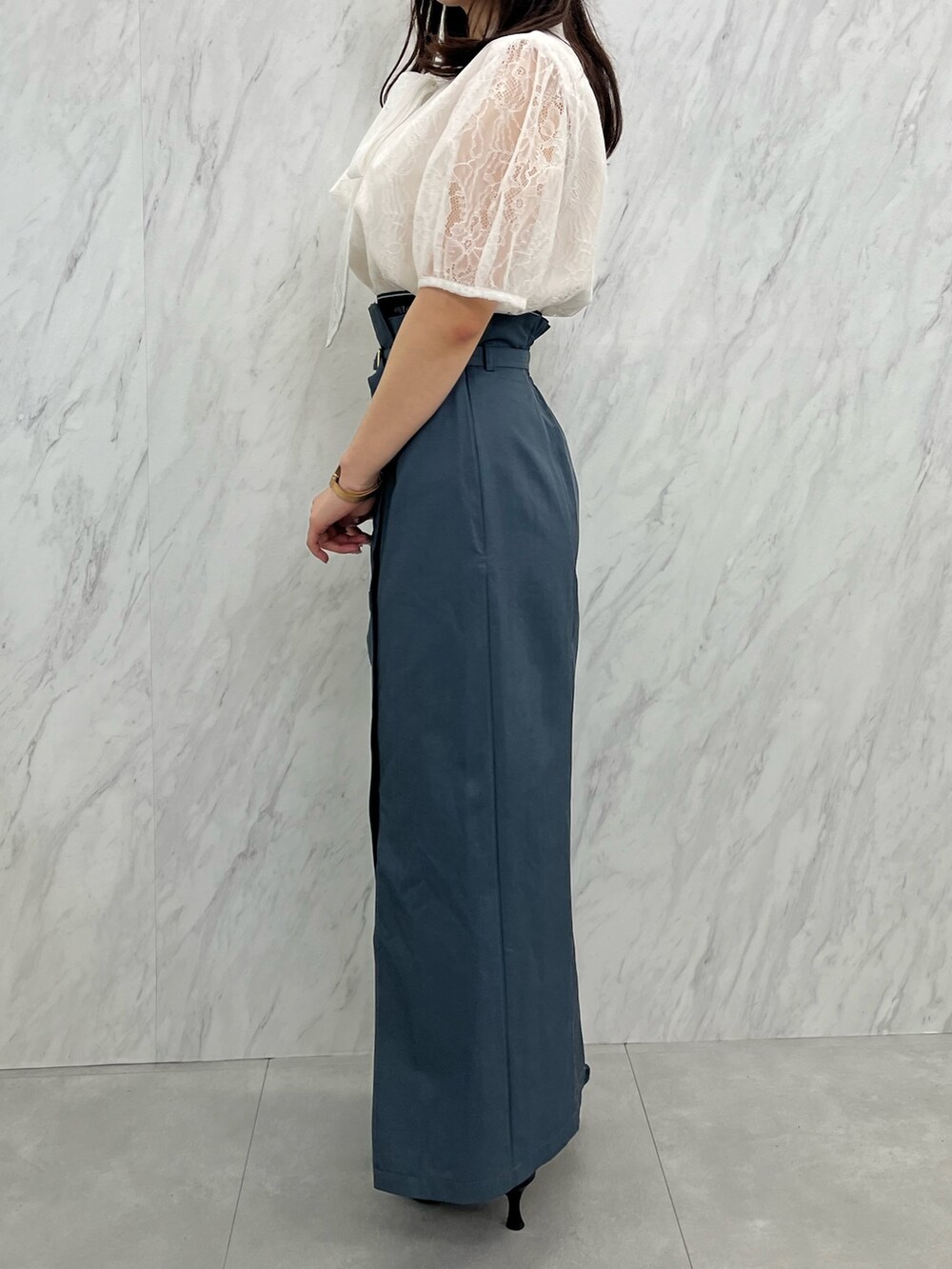 グレー系のスカート、ホワイト系のシャツ/ブラウス、ブラック系のパンプスを着用したレディースの夏コーディネートの3枚目の写真