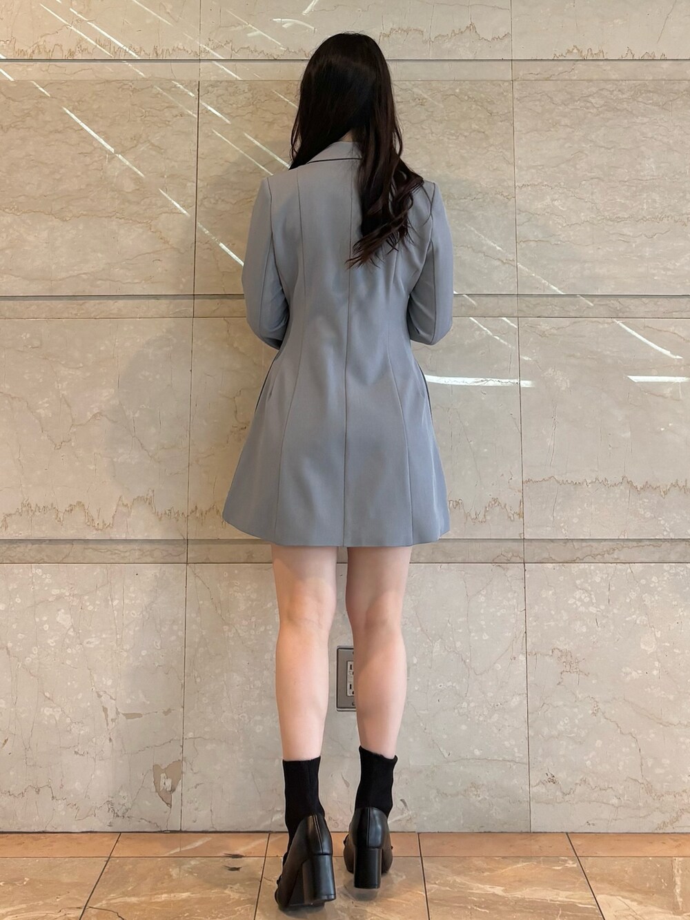 グレー系のワンピース、ブラック系のブーツを着用したレディースの冬コーディネートの4枚目の写真