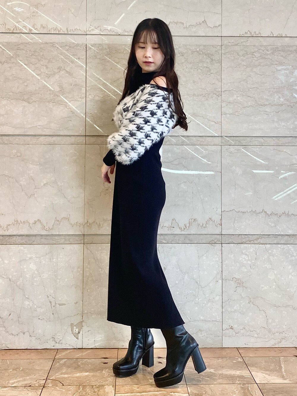 ブラック系のワンピース、ブラック系のブーツを着用したレディースの秋コーディネートの3枚目の写真