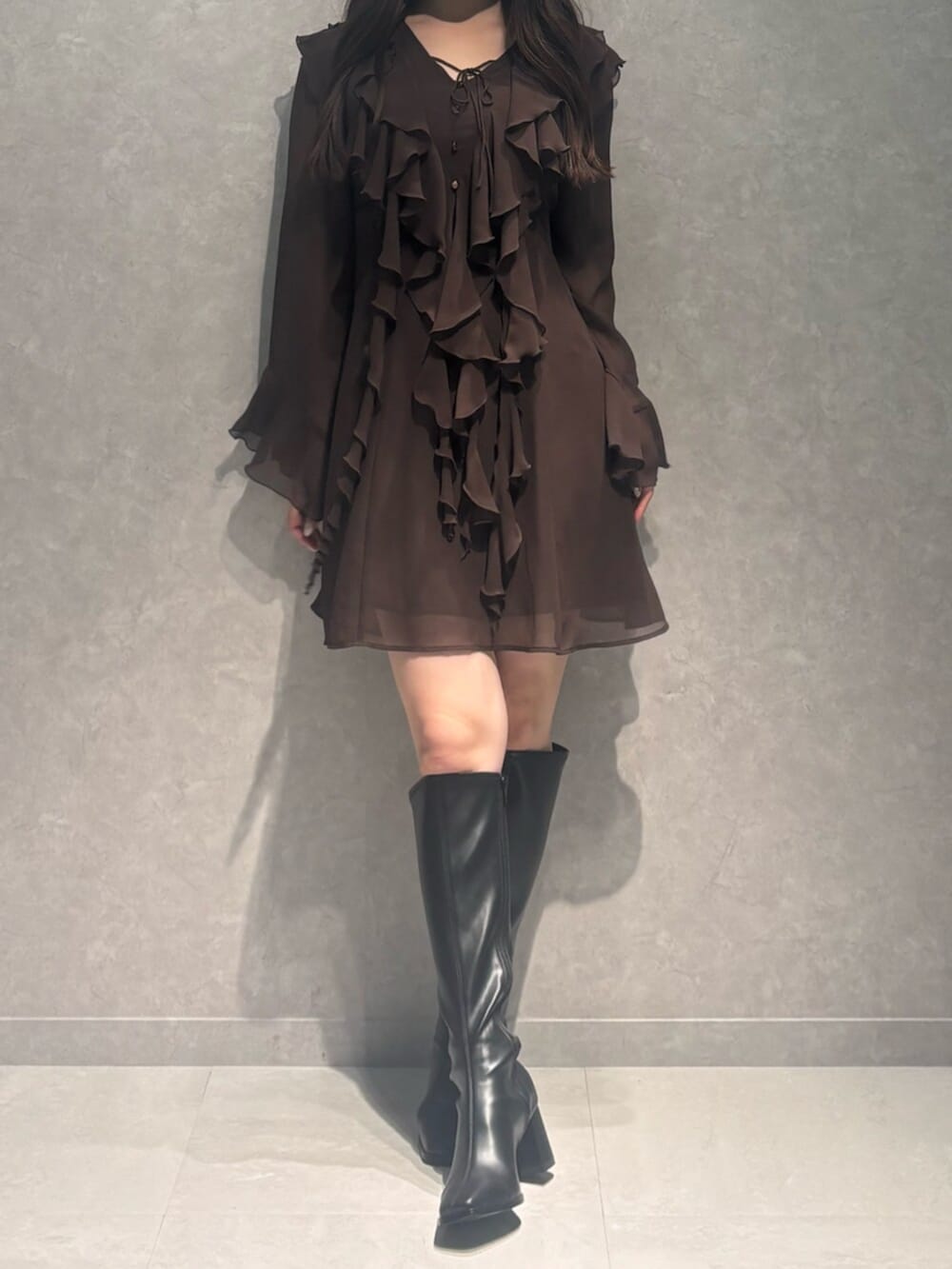 ブラック系のブーツ、ブラウン系のワンピースを着用したレディースの秋コーディネートの5枚目の写真