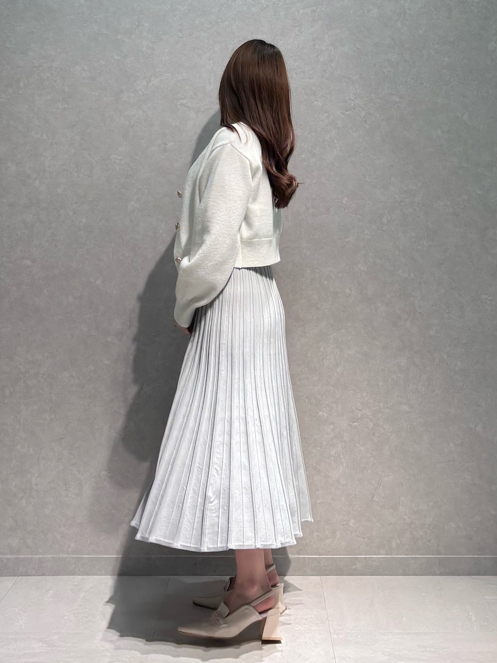 グレー系のワンピース、ホワイト系のカーディガン/ボレロ、ホワイト系のパンプスを着用したレディースの春コーディネートの4枚目の写真