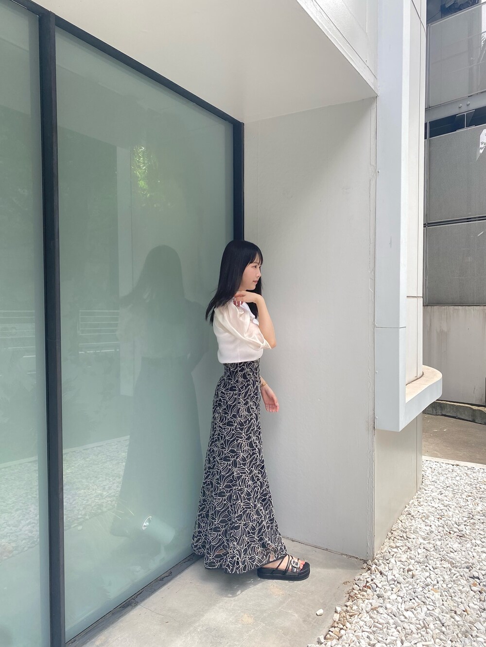 ブラック系のサンダル、ホワイト系のニット/セーター、ブラック系のスカートを着用したレディースの夏コーディネートの3枚目の写真