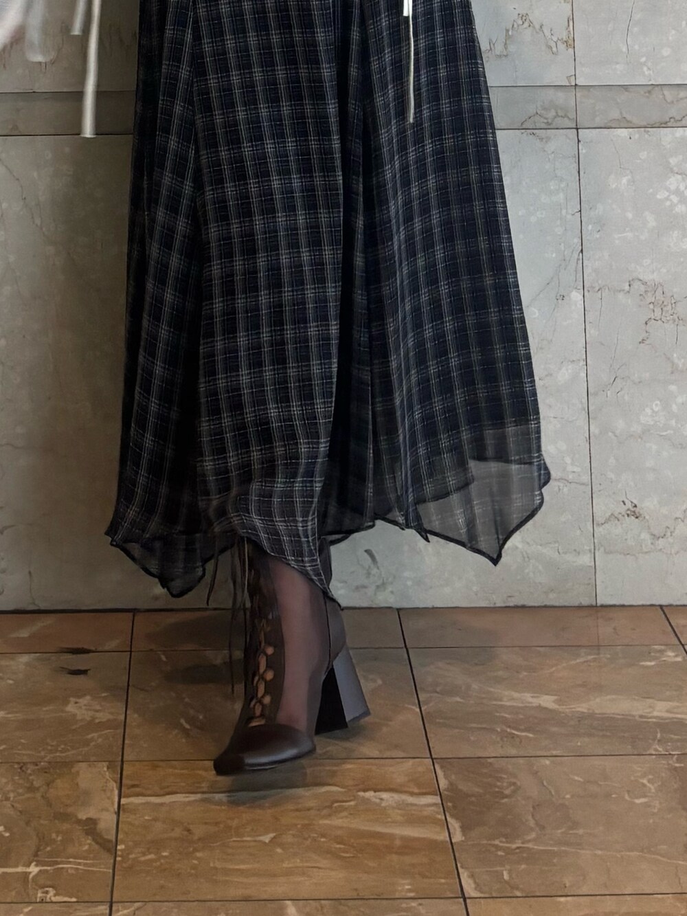 ブラック系のワンピース、ホワイト系のカーディガン/ボレロ、ブラウン系のブーツを着用したレディースの夏コーディネートの5枚目の写真