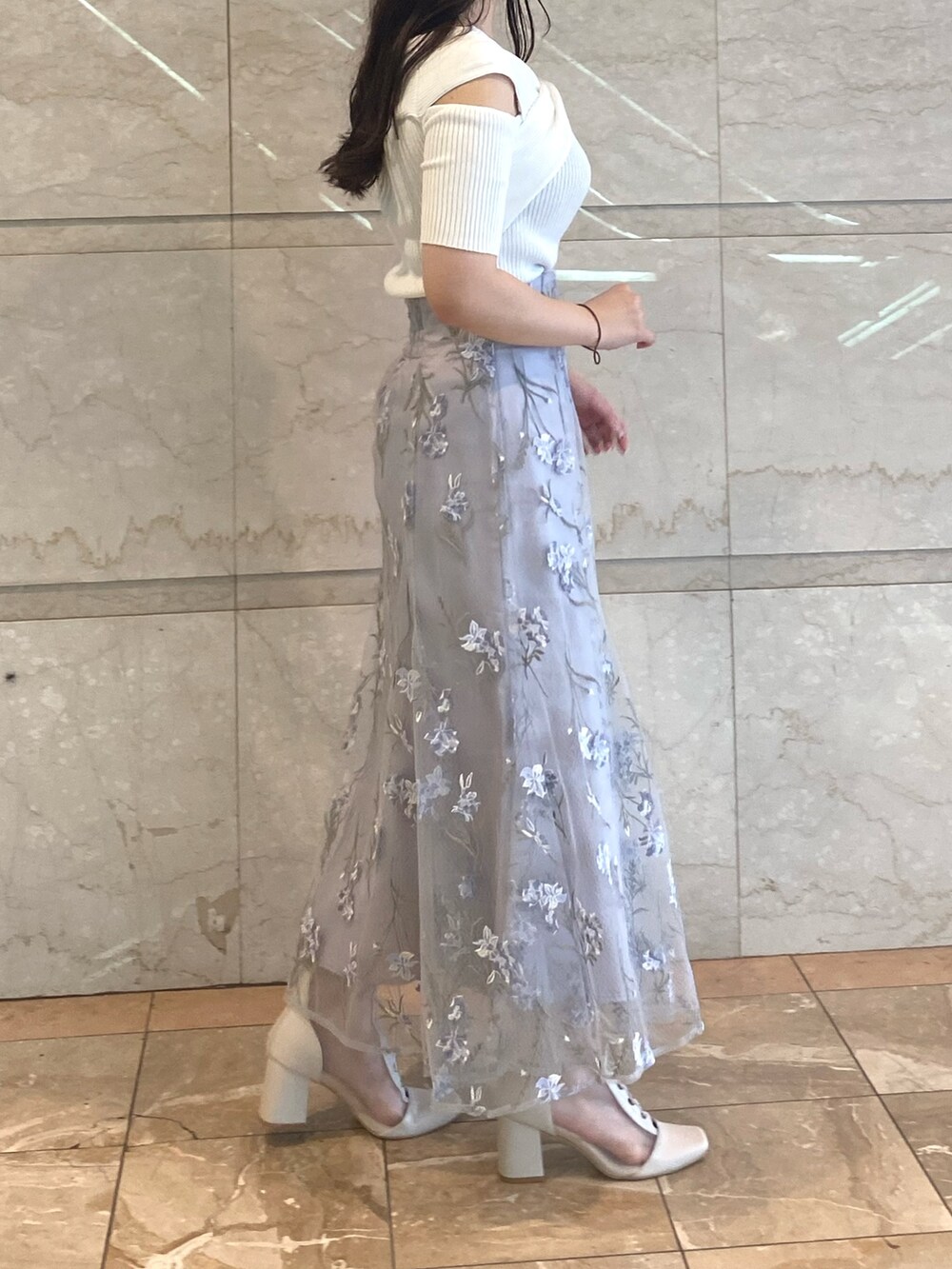 ホワイト系のニット/セーター、ブルー系のスカート、ホワイト系のブーツを着用したレディースの夏コーディネートの5枚目の写真