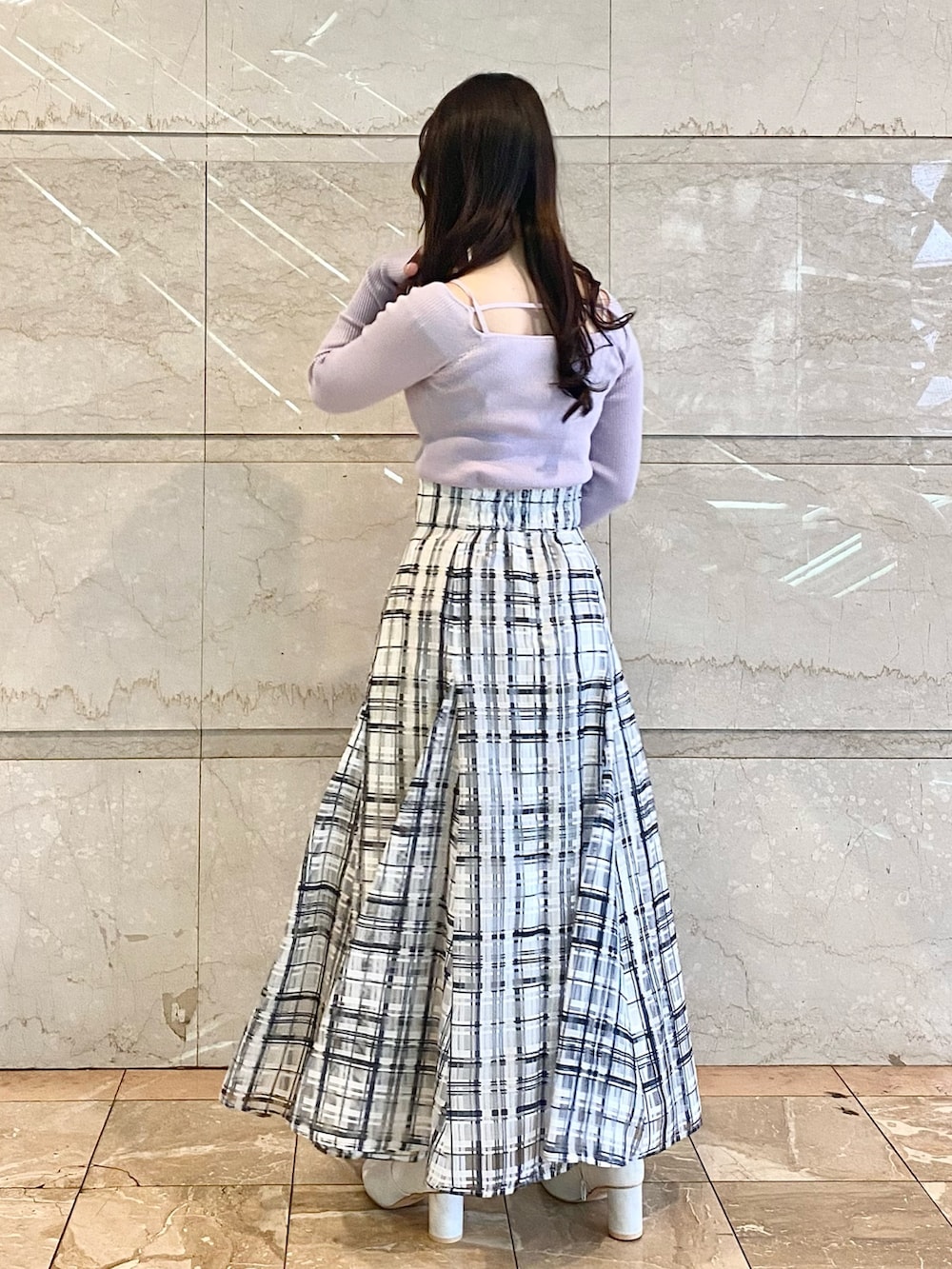 パープル系のニット/セーター、ホワイト系のスカート、ホワイト系のブーツを着用したレディースの冬コーディネートの3枚目の写真