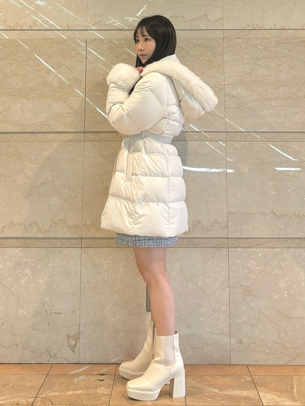 ホワイト系のダウンジャケット/コート、ホワイト系のブーツ、ホワイト系のスカートを着用したレディースの秋コーディネートの5枚目の写真