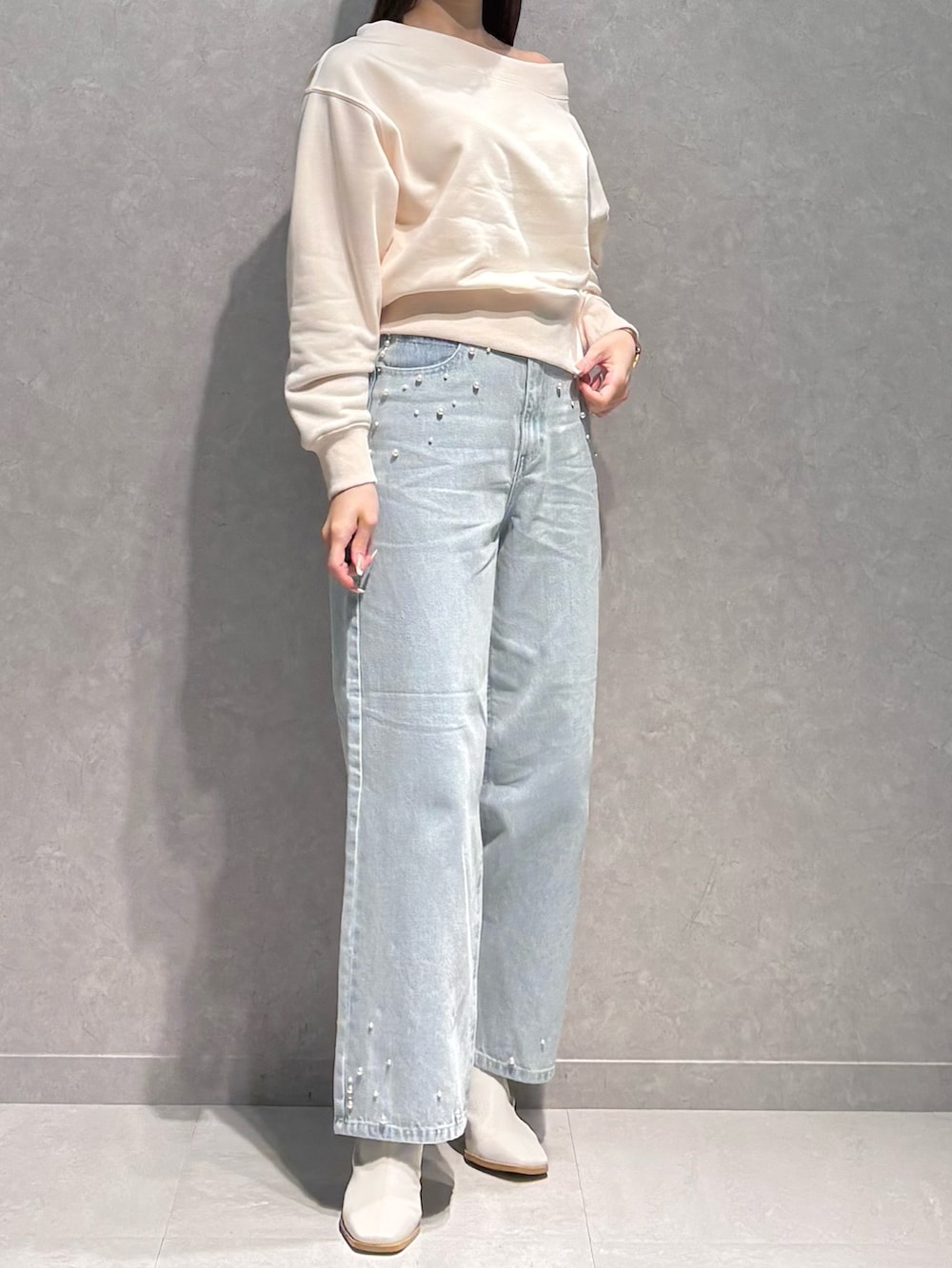 ブルー系のデニムパンツ、ホワイト系のTシャツ/カットソー、ホワイト系のブーツを着用したレディースの春コーディネートの4枚目の写真