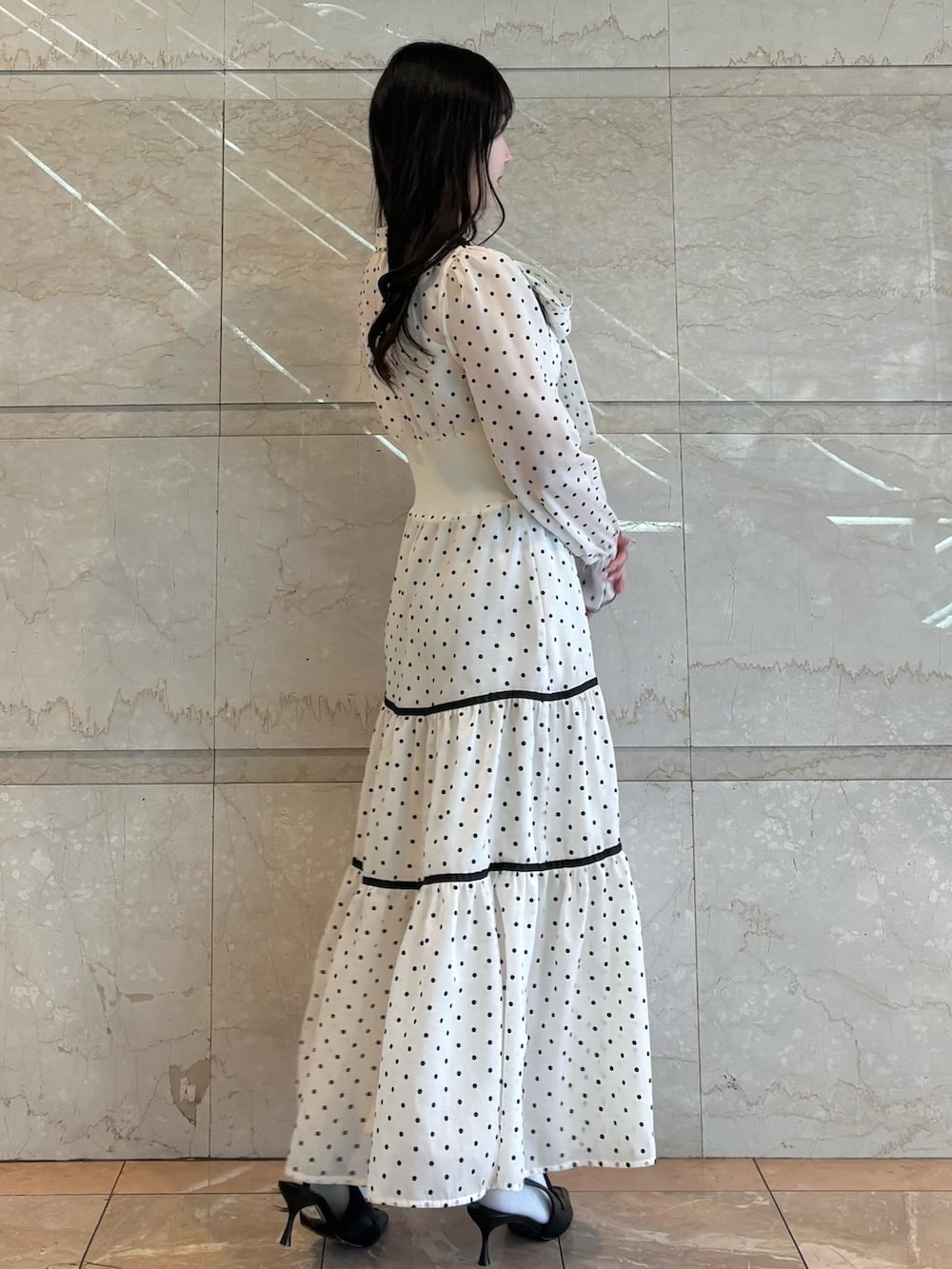 ホワイト系のワンピース、ブラック系のパンプスを着用したレディースの冬コーディネートの3枚目の写真