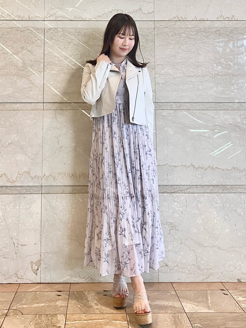 ピンク系のワンピース、その他のサンダル、グレー系のライダースジャケットを着用したレディースの春コーディネートの2枚目の写真