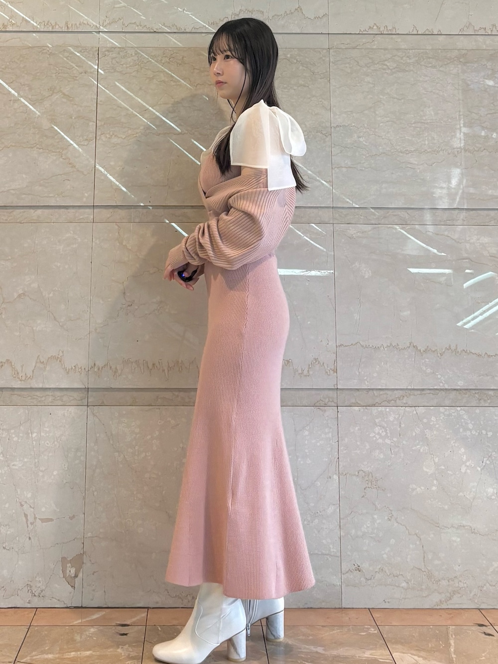 ピンク系のワンピース、ホワイト系のブーツを着用したレディースの冬コーディネートの2枚目の写真