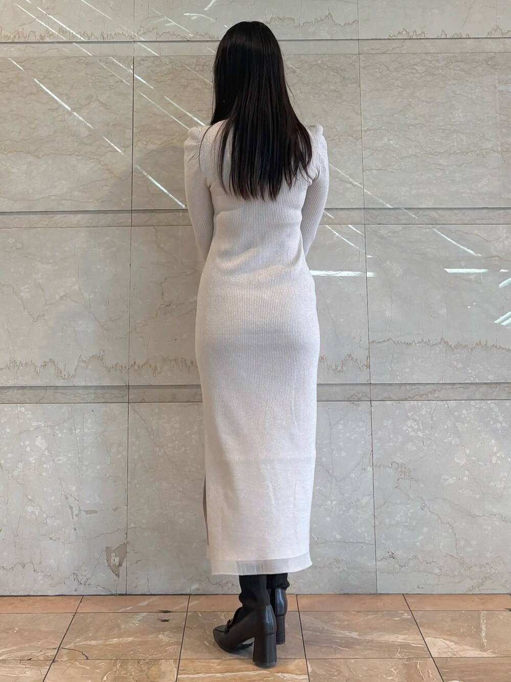 ホワイト系のワンピース、ブラウン系のブーツを着用したレディースの冬コーディネートの2枚目の写真