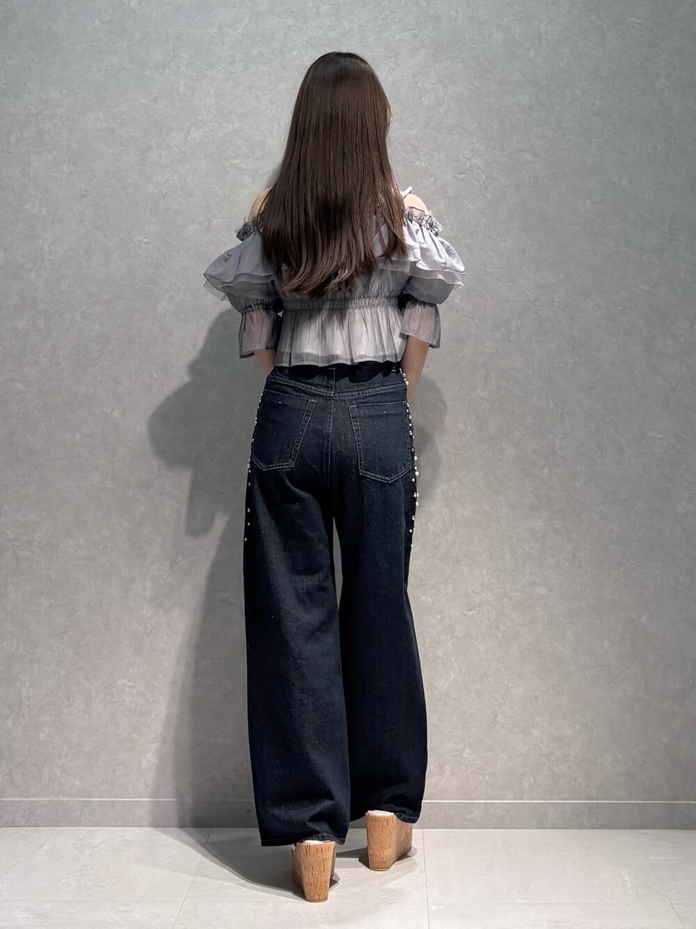 ブルー系のデニムパンツ、グレー系のシャツ/ブラウス、ホワイト系のサンダルを着用したレディースの夏コーディネートの5枚目の写真