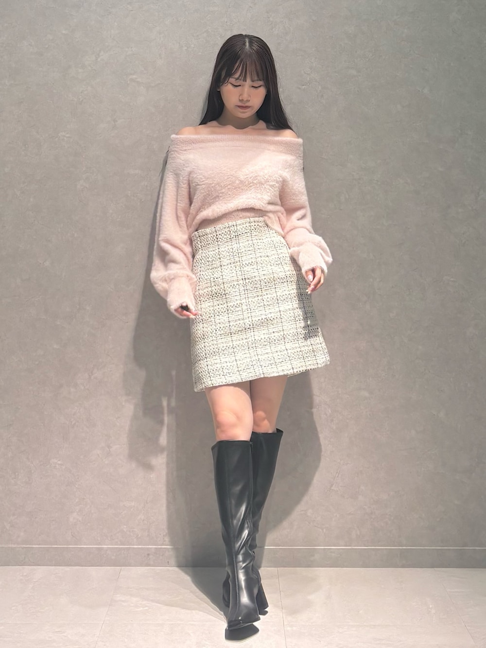 ホワイト系のスカート、ピンク系のニット/セーター、ブラック系のブーツを着用したレディースの秋コーディネートの2枚目の写真