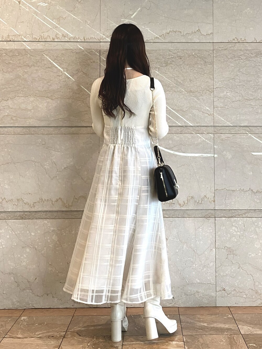 ホワイト系のワンピース、ホワイト系のブーツ、ブラック系のショルダーバッグを着用したレディースの秋コーディネートの7枚目の写真