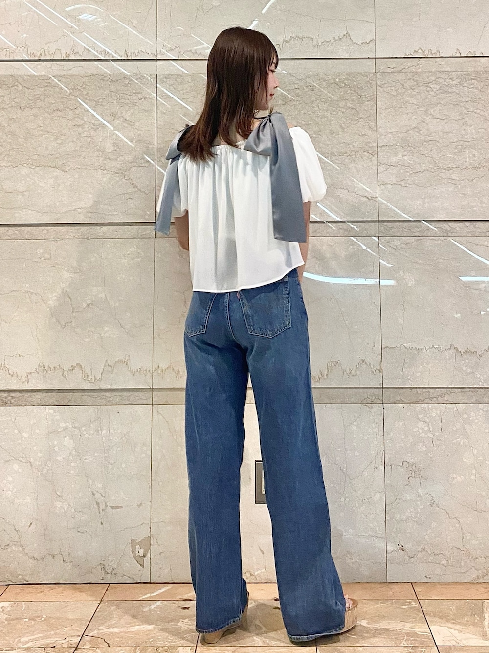 ホワイト系のシャツ/ブラウス、ブルー系のデニムパンツ、その他のサンダルを着用したレディースの春コーディネートの5枚目の写真